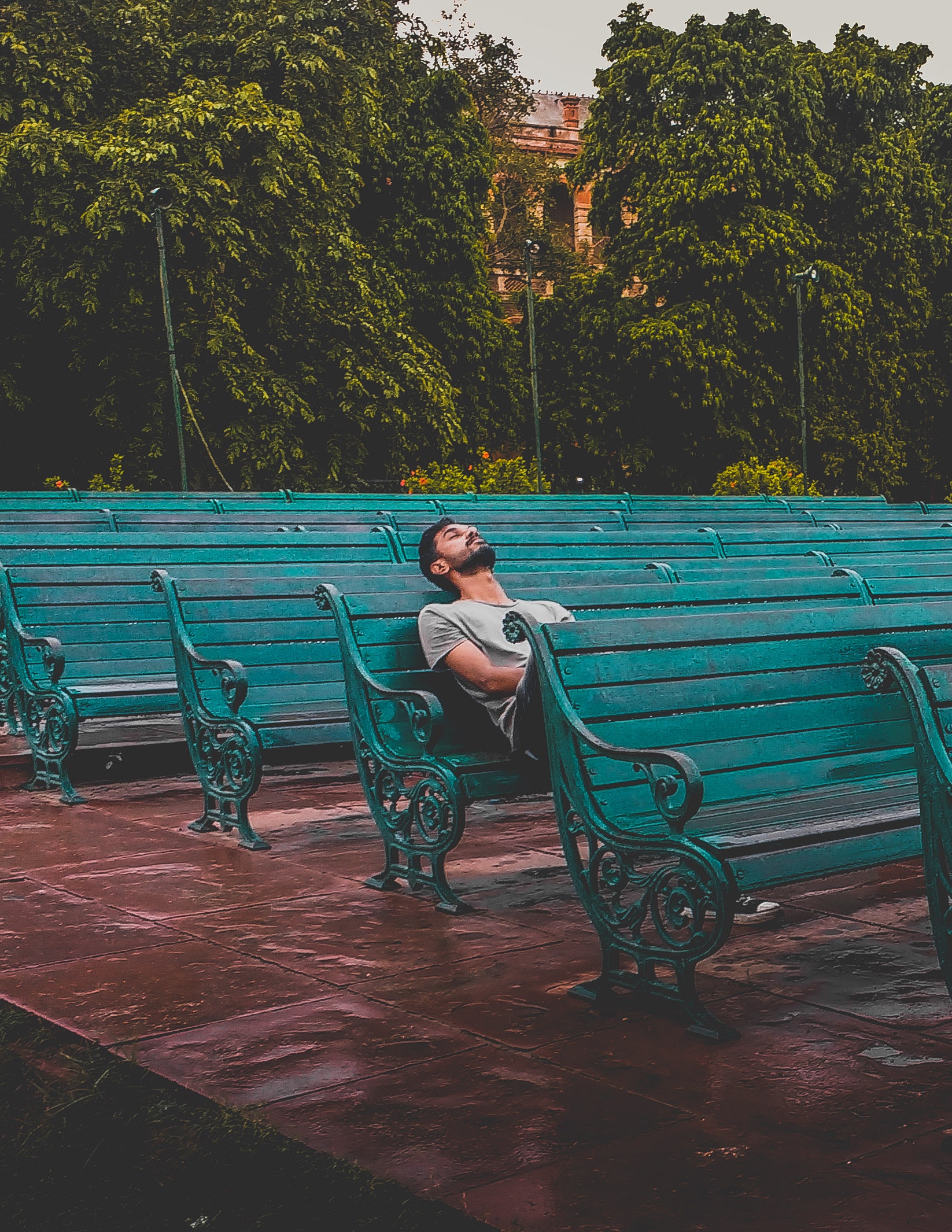 man-sitting-and-closing-eyes-on-teal-bench-1076999