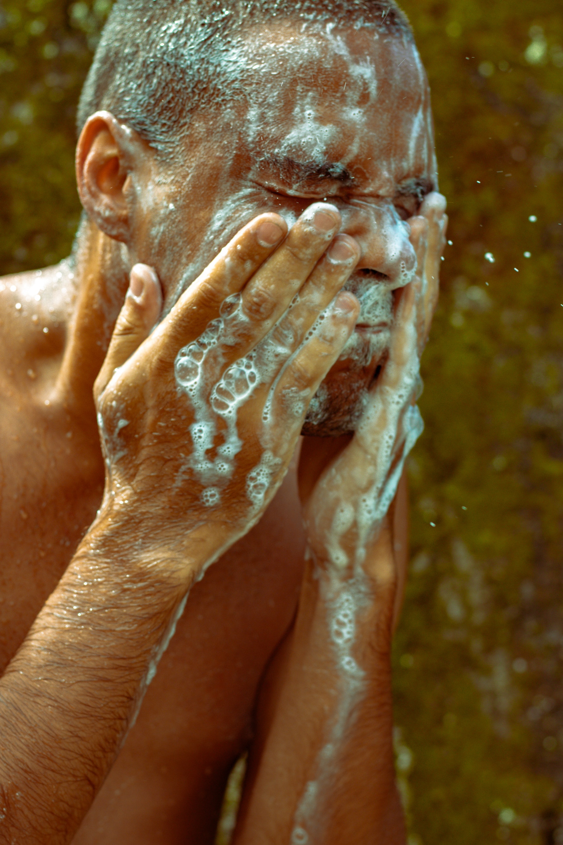 topless-man-washing-his-face-3809099